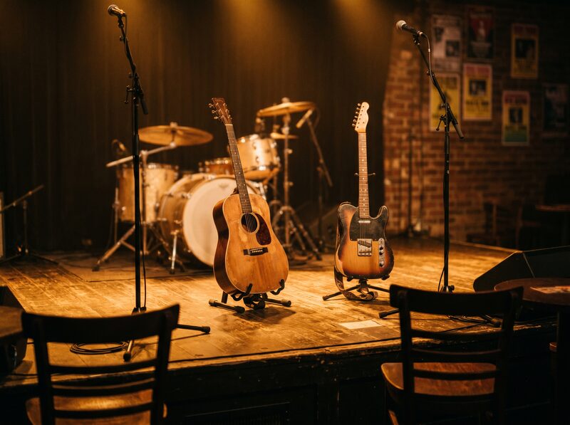 Empty country venue stage with guitars and warm lights.